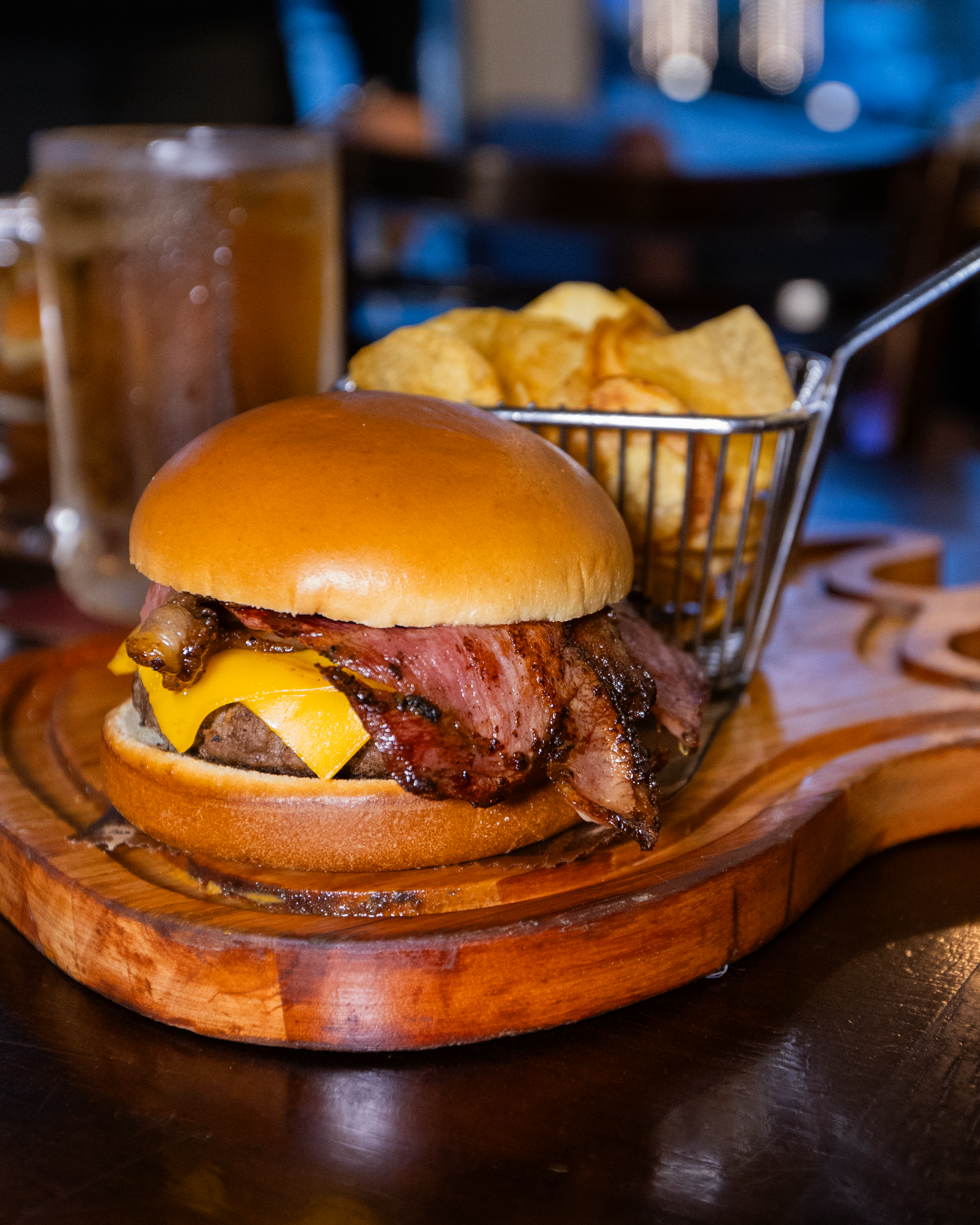 Hambúrguer com bacon e batatas, servido na mesa